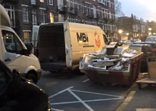 Onze bestelbus en een volle container tijdens een ontruiming in Amsterdam